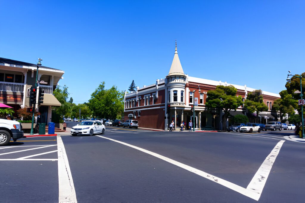 The heart of Los Gatos, California, featuring a busy street with traffic, crosswalks, and a welcoming urban-suburban blend, ideal for homebuyers and investors.