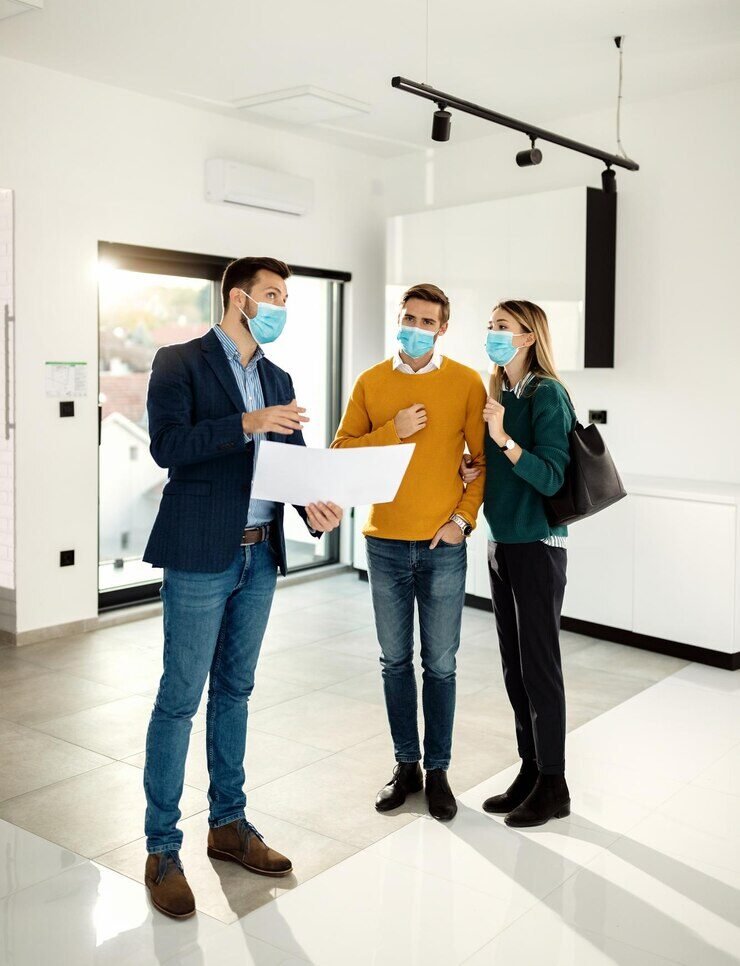 A young couple, first-time homebuyers, reviewing home details with a real estate agent in the San Francisco Bay Area.