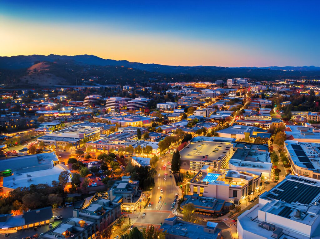 Aerial view of downtown Walnut Creek, CA, at dusk, showcasing the vibrant cityscape, modern homes, and thriving real estate market.